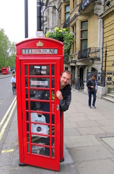 Kuva on Lontoosta. Kuvassa Jan Holmberg kurkistaa kadulla olevasta punaisesta puhelinkopista. Jan Holmberg Mainio blogi janholmberg.weebly.com Copyright Jan Holmberg